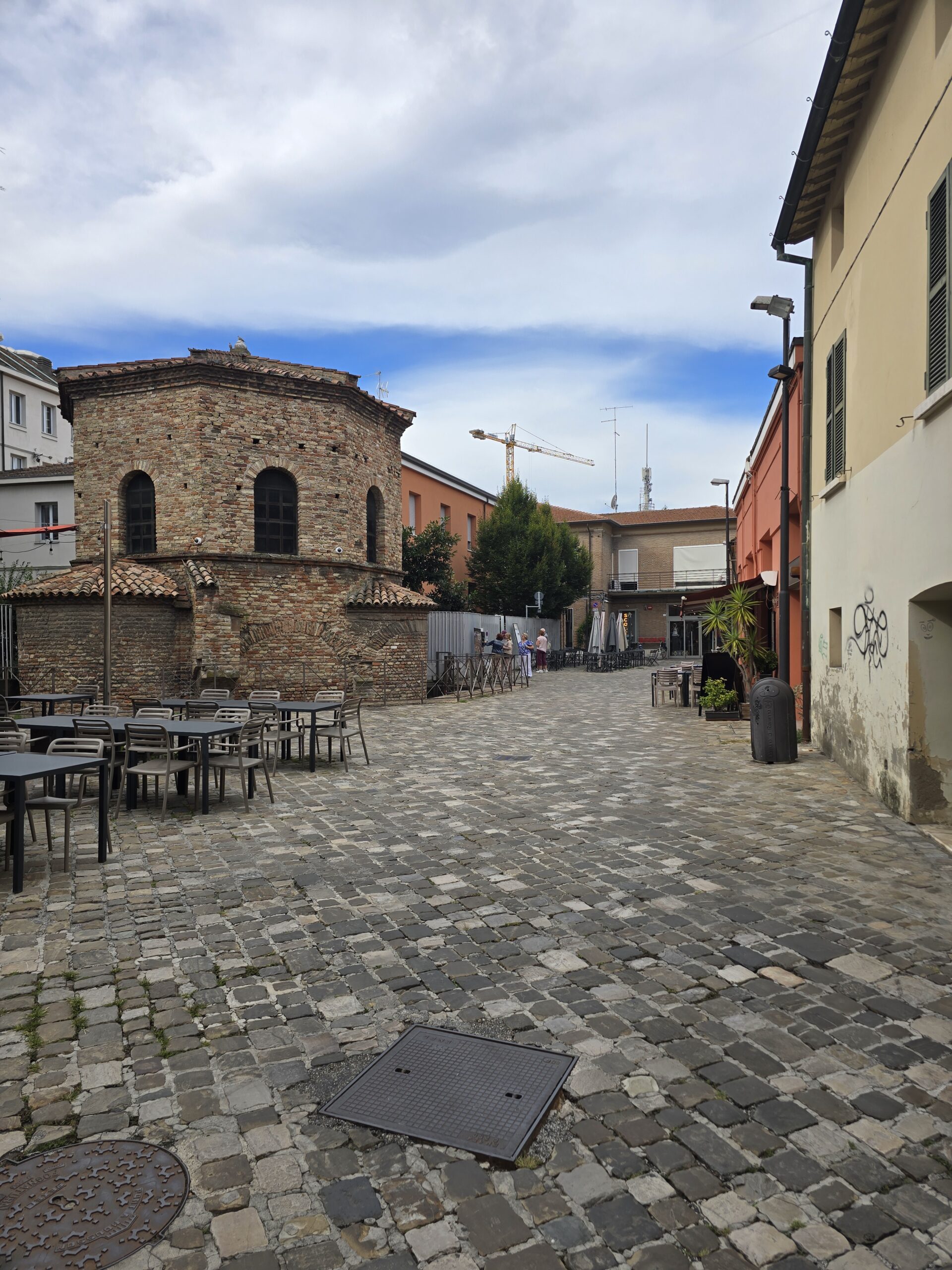 The Arian Baptistery square with café tables